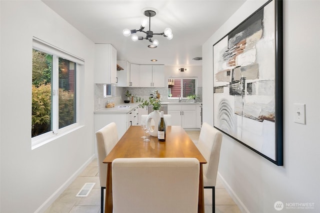 dining room featuring light tile patterned flooring, visible vents, baseboards, and an inviting chandelier