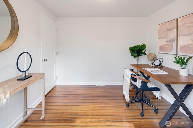 unfurnished office with wood finished floors and baseboards