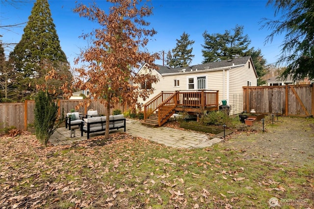 rear view of property featuring a deck, a patio, a fenced backyard, an outdoor hangout area, and stairs