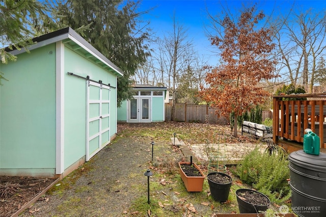 view of yard featuring fence private yard, a vegetable garden, and an outdoor structure