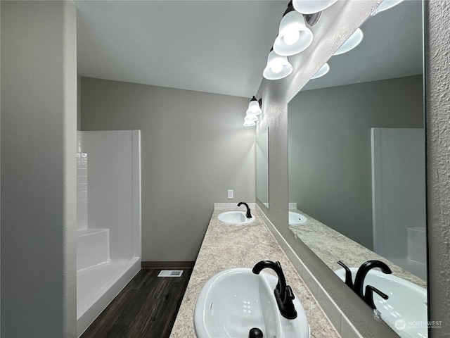 bathroom with vanity, hardwood / wood-style floors, and a shower