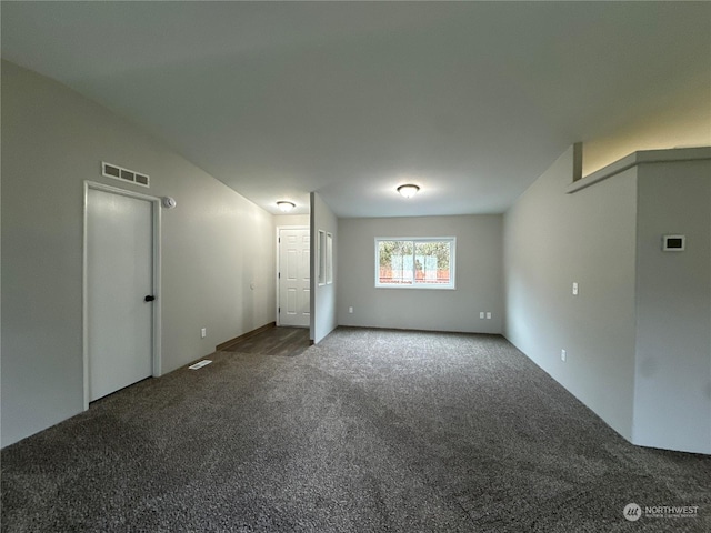 carpeted empty room with vaulted ceiling