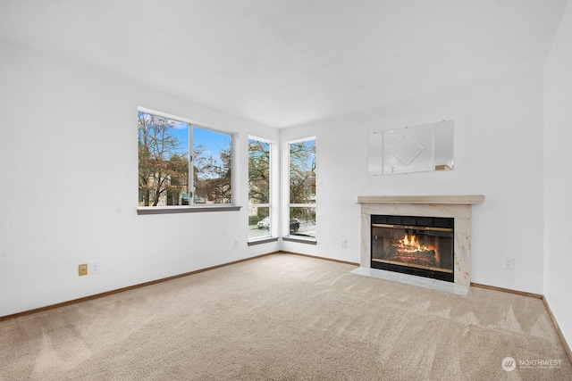 unfurnished living room featuring a premium fireplace and carpet flooring