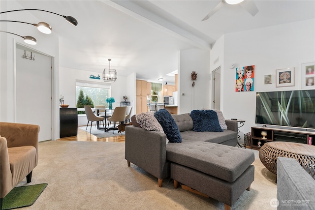 living room featuring beam ceiling and ceiling fan with notable chandelier