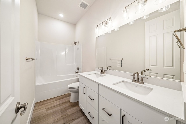 full bathroom with shower / bath combination, vanity, hardwood / wood-style flooring, and toilet