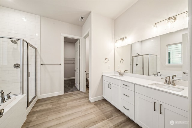 full bathroom featuring hardwood / wood-style flooring, vanity, toilet, and independent shower and bath