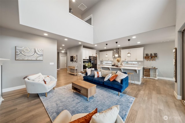 living room featuring a high ceiling and light wood-type flooring