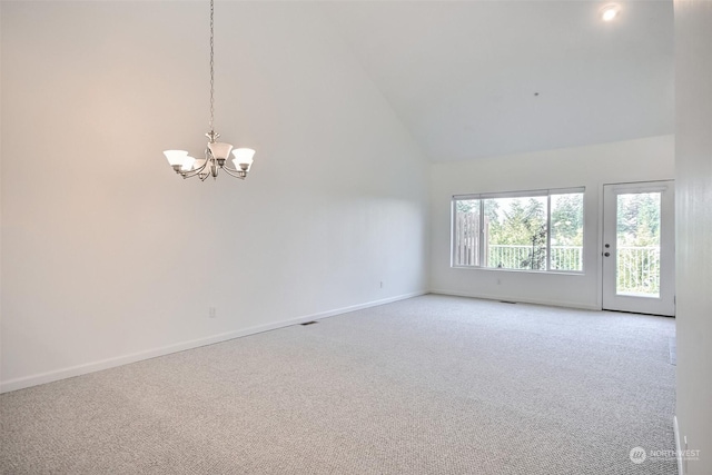 unfurnished room with carpet floors, a notable chandelier, and high vaulted ceiling