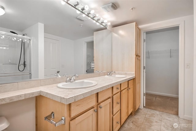 bathroom featuring walk in shower, vanity, and tile patterned flooring