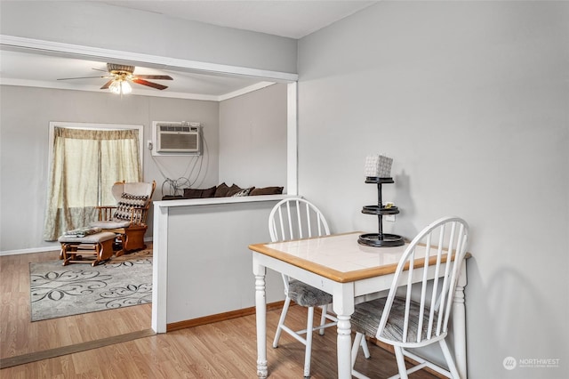 dining area featuring ceiling fan, ornamental molding, a wall mounted AC, and light wood-type flooring