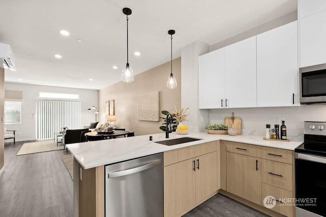 kitchen with light brown cabinetry, sink, hanging light fixtures, kitchen peninsula, and stainless steel appliances