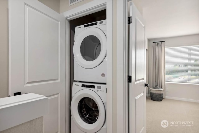 clothes washing area featuring stacked washing maching and dryer and carpet floors