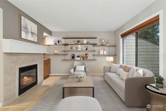 living room with a tiled fireplace and light hardwood / wood-style flooring