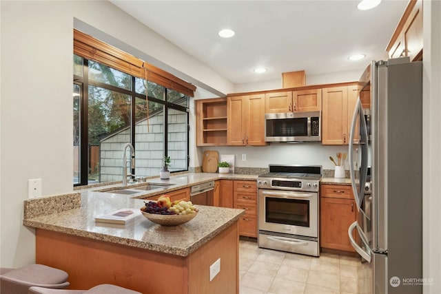 kitchen featuring light stone counters, sink, kitchen peninsula, and appliances with stainless steel finishes