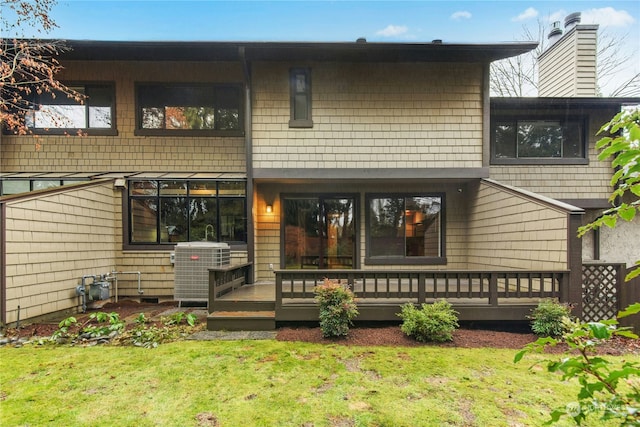 back of house featuring a deck and a lawn