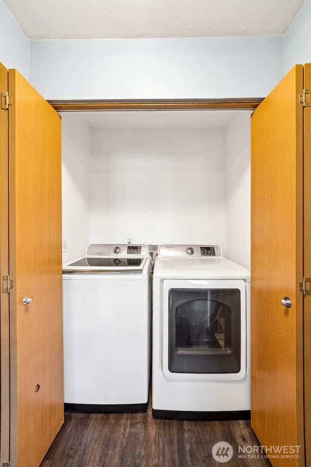 washroom with dark hardwood / wood-style floors and washing machine and dryer