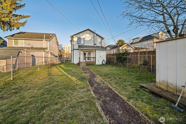 back of property with a yard and a storage unit