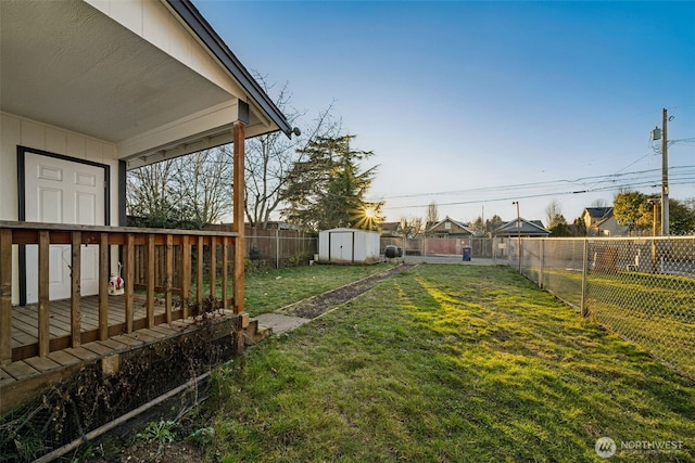 view of yard featuring a deck and a storage unit