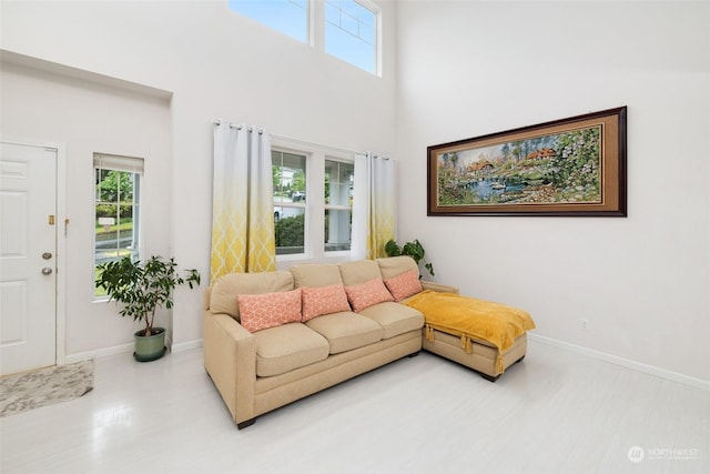 living room with hardwood / wood-style floors, plenty of natural light, and a high ceiling