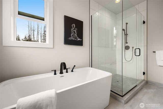 full bathroom featuring a stall shower, a freestanding tub, and recessed lighting