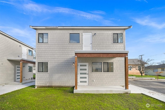 rear view of house with a lawn and a patio area