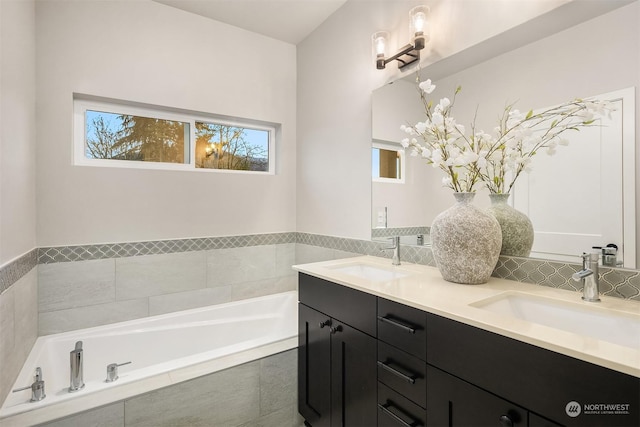 bathroom featuring vanity and tiled tub