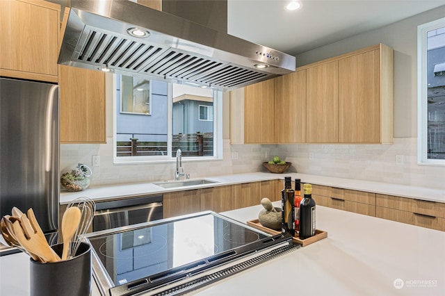 kitchen featuring decorative backsplash, sink, stainless steel fridge, and wall chimney exhaust hood