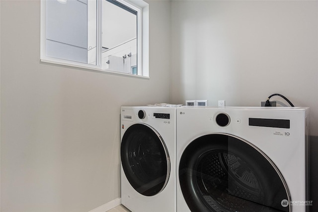 clothes washing area with cabinets and washer and clothes dryer