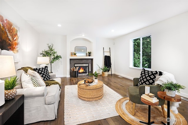 living room with dark hardwood / wood-style flooring and a tile fireplace