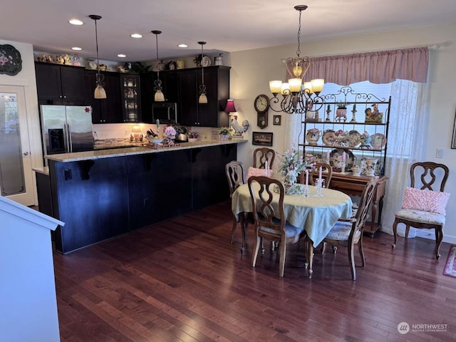 dining area with a wealth of natural light, dark wood-type flooring, and a chandelier