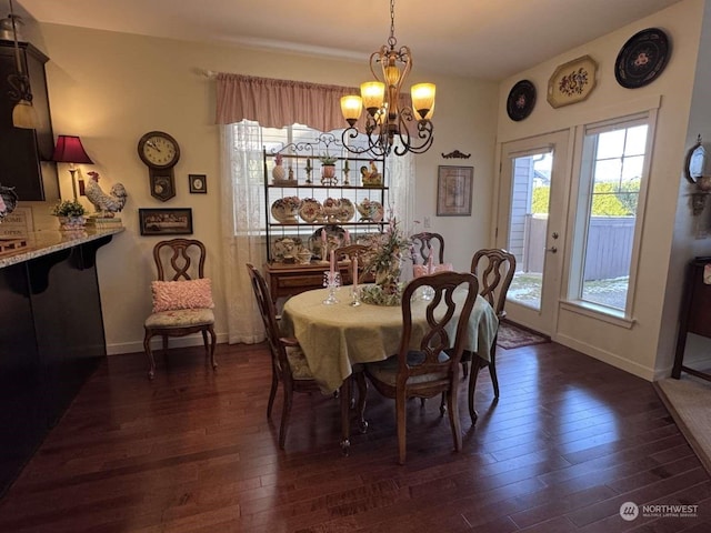 dining room with dark hardwood / wood-style floors and an inviting chandelier