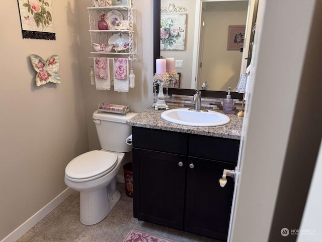 bathroom featuring tile patterned flooring, vanity, and toilet