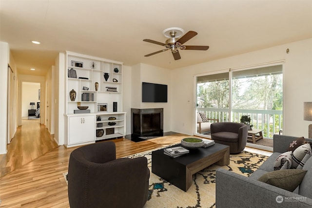 living room with ceiling fan and light wood-type flooring