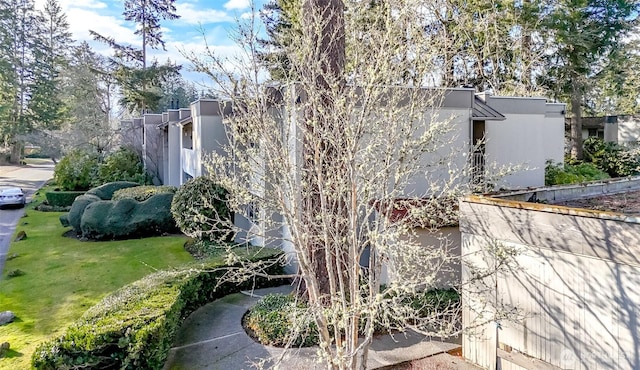 view of home's exterior with stucco siding and a yard