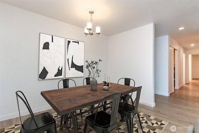 dining room featuring baseboards, recessed lighting, light wood-style flooring, and a notable chandelier