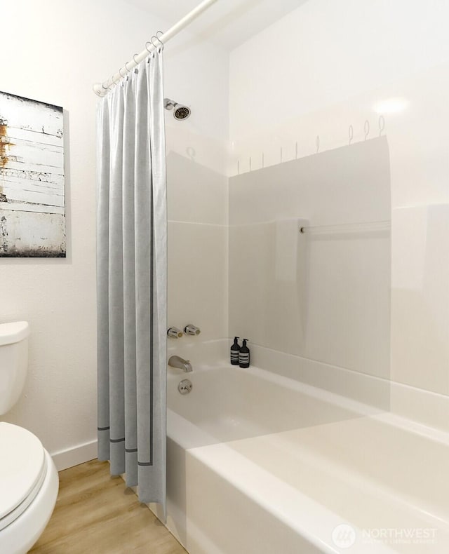 bathroom with toilet, baseboards, wood finished floors, and shower / bath combo with shower curtain