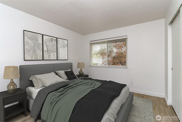 bedroom with light wood-style floors and baseboards
