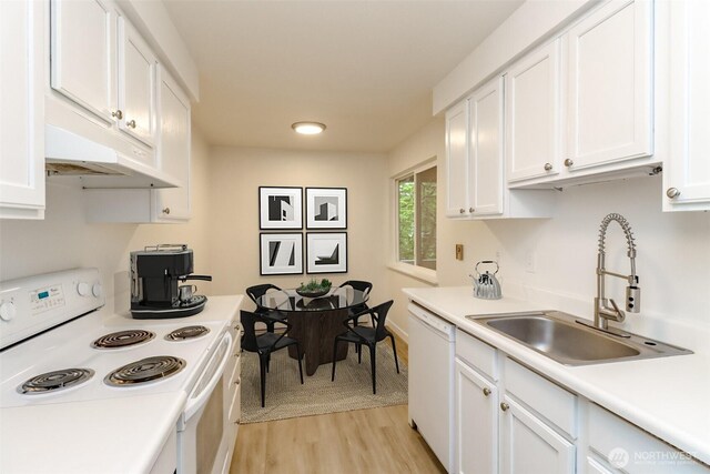 kitchen with a sink, light wood-style flooring, white cabinets, and white appliances