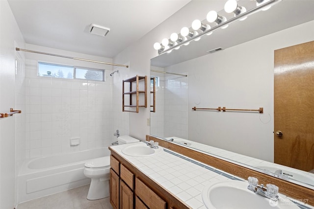 bathroom featuring double vanity, tile patterned flooring, toilet, and a sink