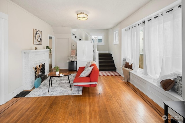 living room with a brick fireplace and light wood-type flooring