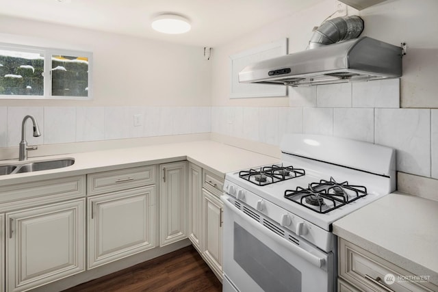 kitchen featuring extractor fan, sink, dark wood-type flooring, and white gas range oven