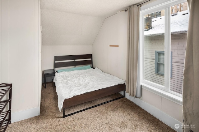 bedroom with vaulted ceiling, carpet, and a textured ceiling