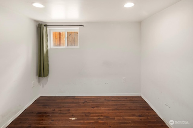 unfurnished room with dark wood-type flooring