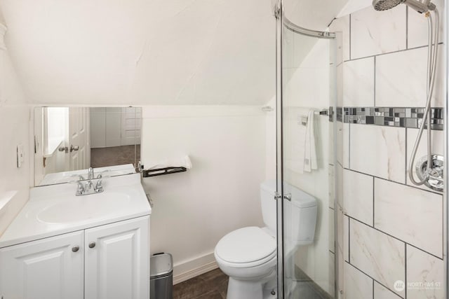 bathroom with vanity, a shower with shower door, lofted ceiling, and toilet