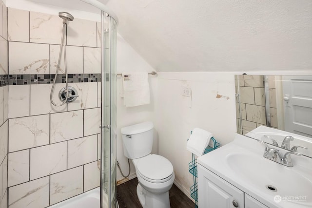 bathroom with toilet, wood-type flooring, vaulted ceiling, vanity, and a shower with door