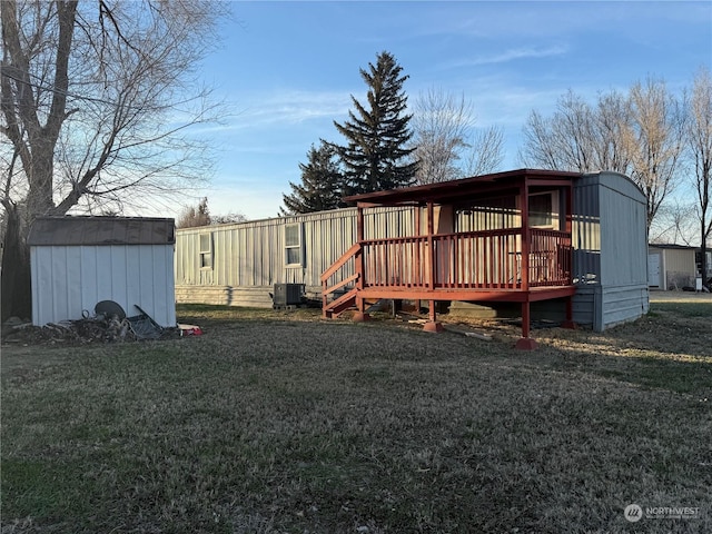 exterior space with a storage unit, cooling unit, a deck, and a lawn