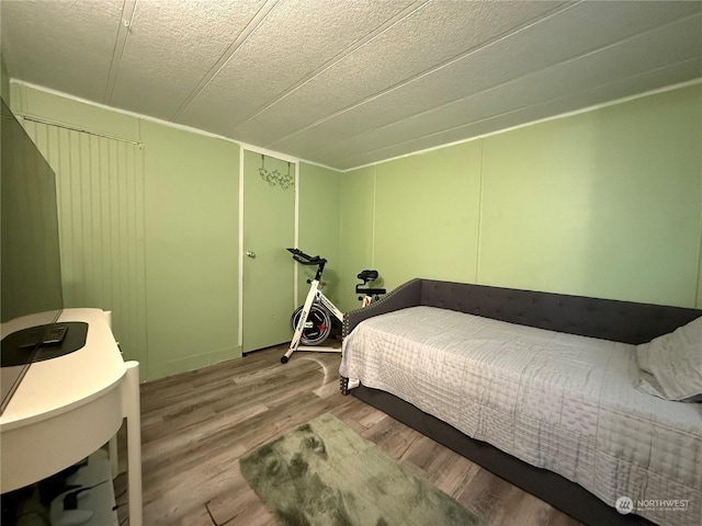 bedroom with a textured ceiling and light wood-type flooring