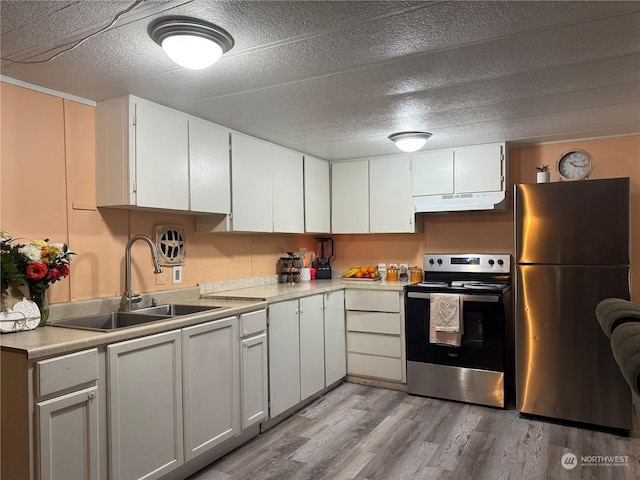 kitchen with sink, white cabinetry, a textured ceiling, light wood-type flooring, and stainless steel appliances