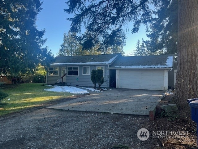 single story home featuring a garage and a front yard