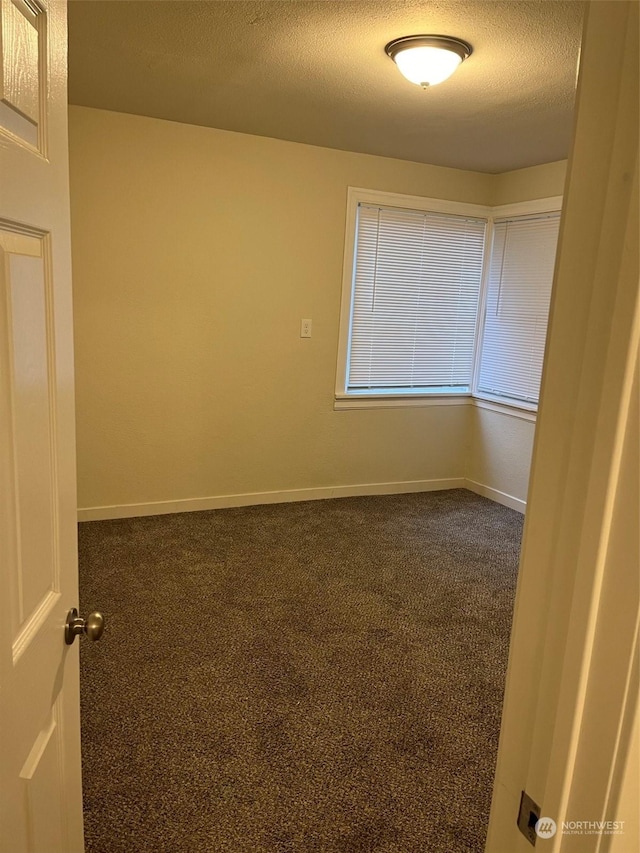 carpeted spare room with a textured ceiling